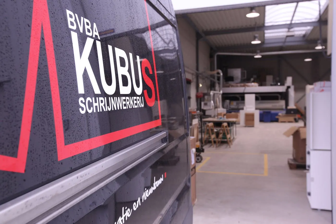 Bestelwagen van Kubus aan de ingang van het atelier met CNC-machine