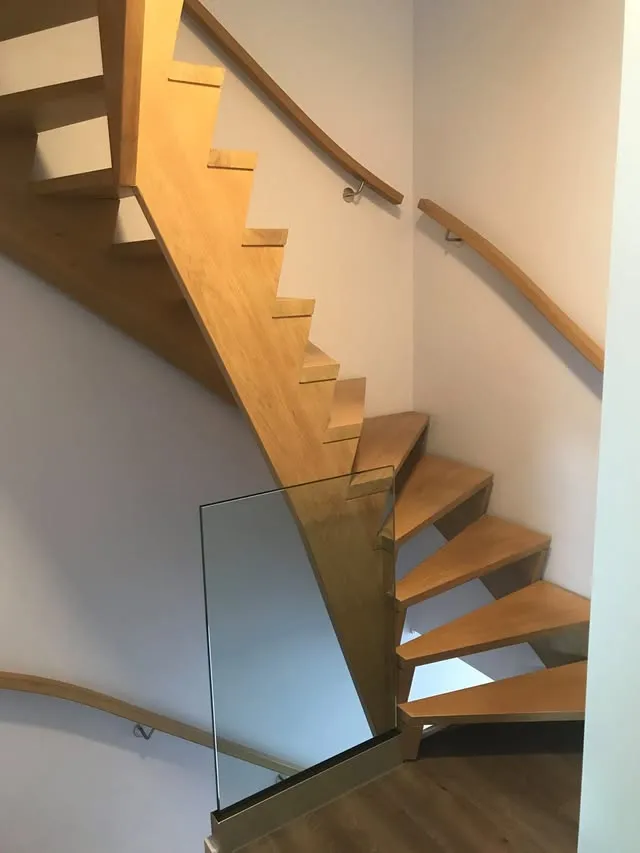 Eiken trap met glazen balustrade en houten leuning