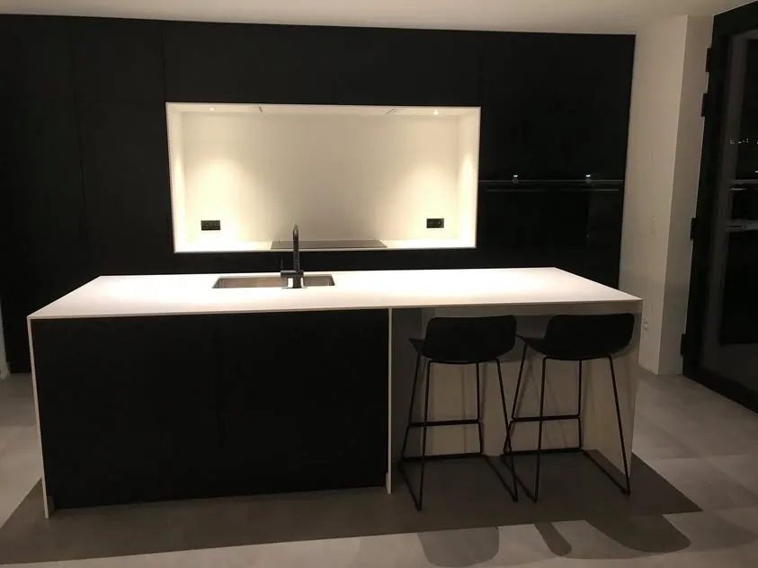 Zwarte keuken op maat met wit Himacs werkblad en eiland