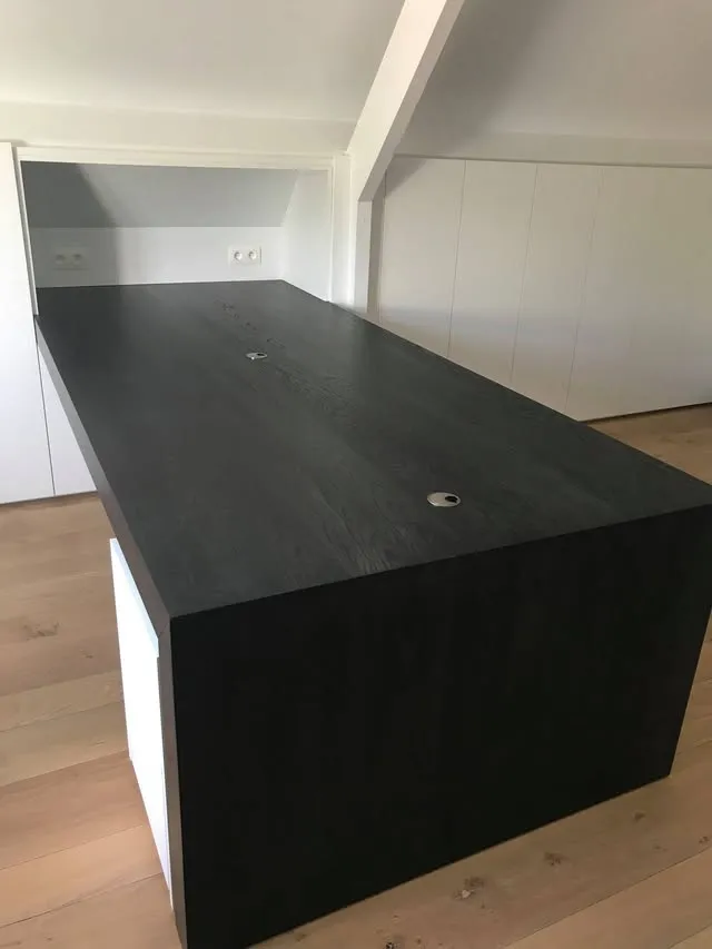 Zwart eiken bureau in een zolderkantoor