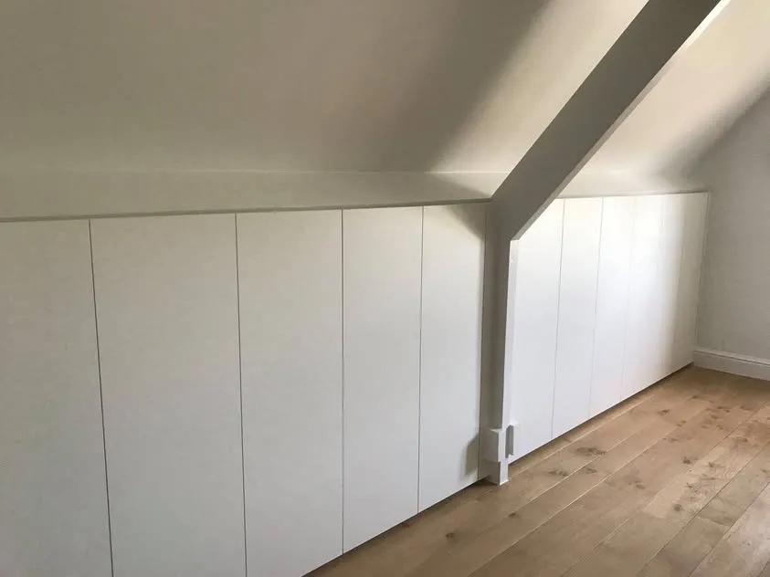 Witte kasten in de schuine wand van een zolder