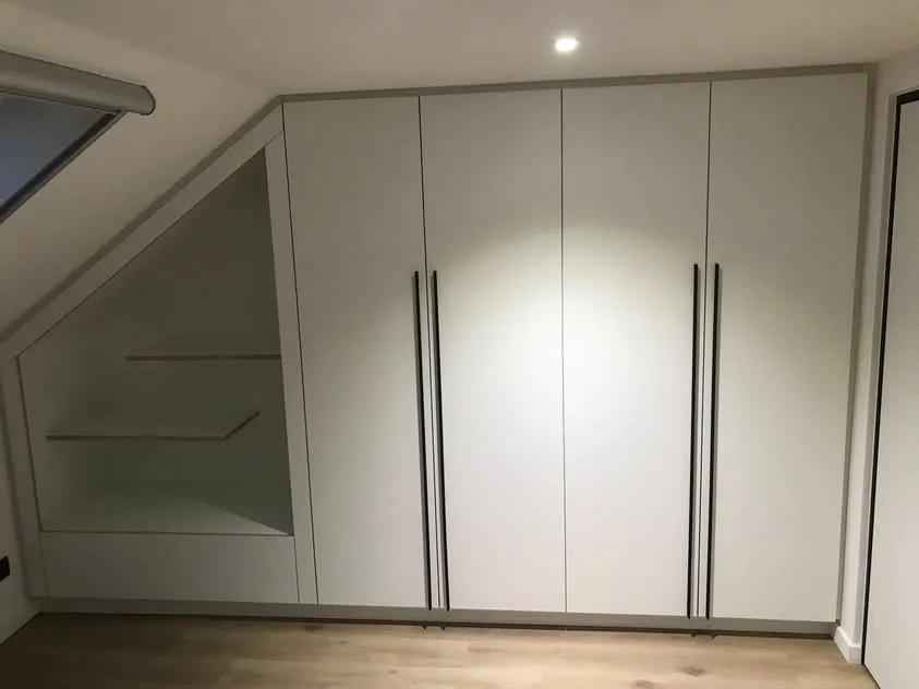 Witte kastdeuren in een zolderkamer met schuin dak